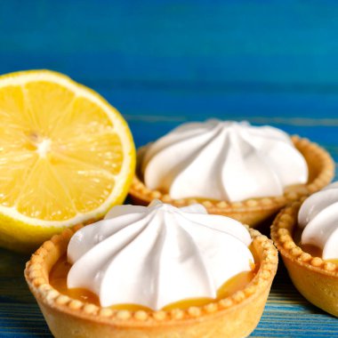 Limonlu turtalar, ev yapımı mini tart kekleri limonlu ve kremşantili, mavi arka plan fotokopi alanı