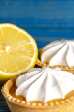 Limonlu turtalar, ev yapımı mini tart kekleri limonlu ve kremşantili, mavi arka plan fotokopi alanı