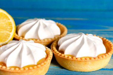 Limonlu turtalar, ev yapımı mini tart kekleri limonlu ve kremşantili, mavi arka plan fotokopi alanı