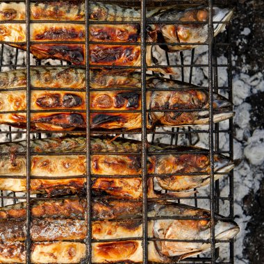 Izgara ızgarasının içinde ızgara ızgara ızgara ızgara ızgara ızgara ızgara ızgarası var. Açık hava barbekü ızgarası kullanarak yerel deniz balığı hazırlığı