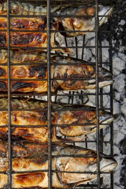 Izgara ızgarasının içinde ızgara ızgara ızgara ızgara ızgara ızgara ızgara ızgarası var. Açık hava barbekü ızgarası kullanarak yerel deniz balığı hazırlığı