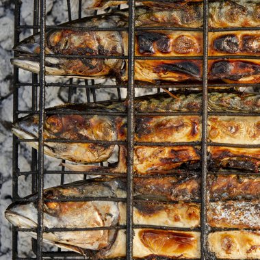 Izgara ızgarasının içinde ızgara ızgara ızgara ızgara ızgara ızgara ızgara ızgarası var. Açık hava barbekü ızgarası kullanarak yerel deniz balığı hazırlığı