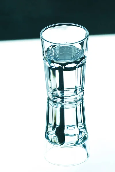 反射と鋭い影を持つきれいな水を持つガラス トップ表示 — ストック写真