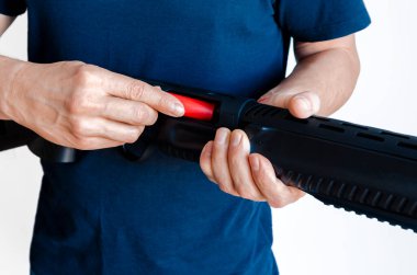 Adam tüfeği cephaneyle dolduruyor. Pompa delikli silahı şarj ediyorum. Yakın plan fotoğraf..