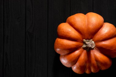 Siyah ahşap bir masada sarı balkabağı