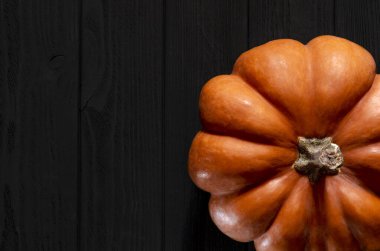 Siyah ahşap bir masada sarı balkabağı