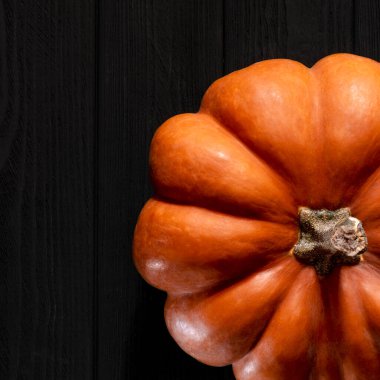 Siyah ahşap bir masada sarı balkabağı