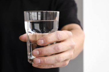 Bir adamın elinde temiz eritilmiş su dolu bir bardak. Su dengesi