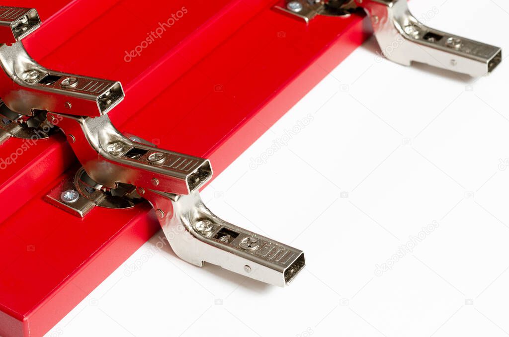 Red fronts for a chest of drawers with metal hinges lie on a white background.