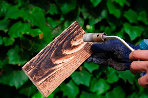 Geleneksel tekniği kullanan profesyonel bir marangoz. Gaz ocağıyla odun yakmak. DIY süreci.