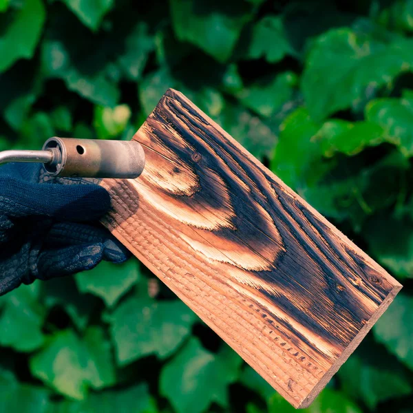 Egy Férfi Tűzzel Égeti Deszkákat Egy Gázégőből Fafeldolgozás Gyönyörű Textúrájának — Stock Fotó