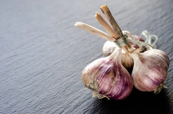 Garlic bulbs and garlic cloves on a black background. Close-up, flat lay, top view. Food background, selective focus.