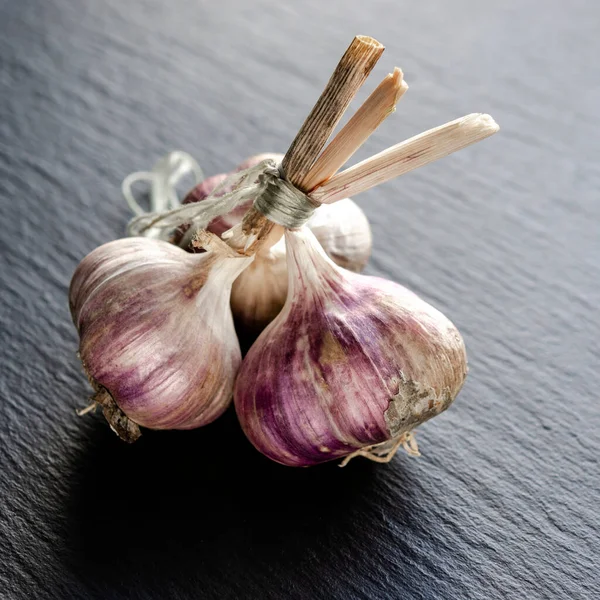 Garlic bulbs and garlic cloves on a black background. Close-up, flat lay, top view. Food background, selective focus.