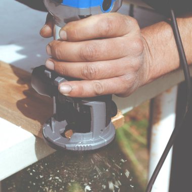 Marangozun el yapımı ahşap modem makinesiyle yakın çekimi. Çam ağacından yapılma ahşap döşeme konsept mobilyalara bir eğim yönlendirme