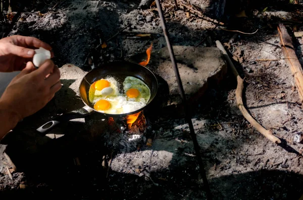 Breakfast in the woods. Breakfast on a hike. Classic egg in a frying pan on a campfire