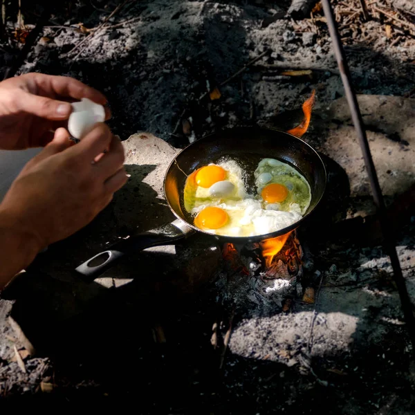 Breakfast in the woods. Breakfast on a hike. Classic egg in a frying pan on a campfire