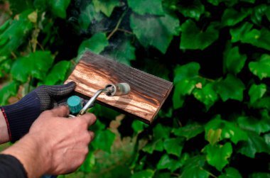 Geleneksel tekniği kullanan profesyonel bir marangoz. Gaz ocağıyla odun yakmak. DIY süreci.