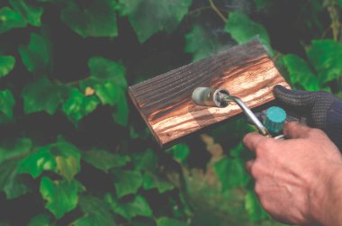Geleneksel tekniği kullanan profesyonel bir marangoz. Gaz ocağıyla odun yakmak. DIY süreci.
