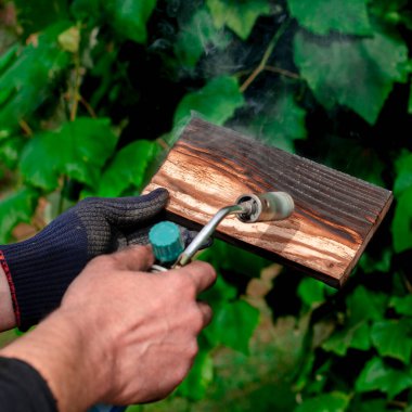 Geleneksel tekniği kullanan profesyonel bir marangoz. Gaz ocağıyla odun yakmak. DIY süreci.