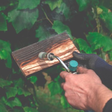 Geleneksel tekniği kullanan profesyonel bir marangoz. Gaz ocağıyla odun yakmak. DIY süreci.