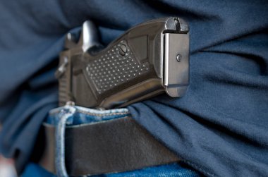 Siyah kuşağın arkasındaki siyah travmatik silah.