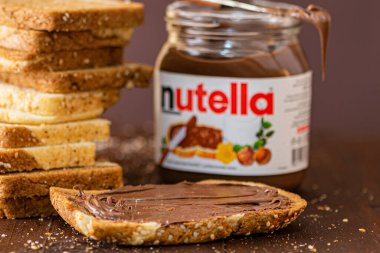 Simferopol, Ukrayna - 3 Ekim 2018: Nutella ve mermer ekmek dilimlenmiş fındık kavanoz rustik ahşap masa üzerinde yayılmış.