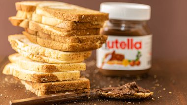 Simferopol, Ukrayna - 3 Ekim 2018: Nutella ve mermer ekmek dilimlenmiş fındık kavanoz rustik ahşap masa üzerinde yayılmış.