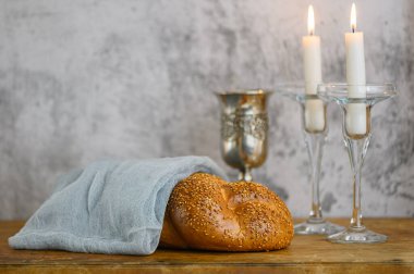 Şabat Şalom Challah ekmeği, Şabat şarabı ve ahşap masada mumlar..