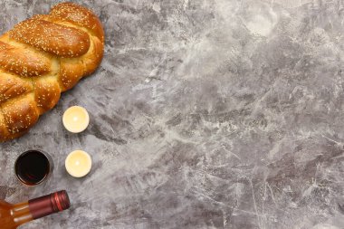 Şabat Şalom Challah ekmeği, Şabat şarabı ve mumlar masada. Gri arka plan. Üst Manzara. Boşluğu kopyala.