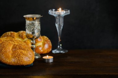 Şabat Şalom Challah ekmeği, Şabat şarabı ve ahşap masada mumlar. Yan görüş. Boşluğu kopyala.