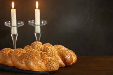 Şabat Şalom - Challah ekmeği, ahşap masada şabat mumları.