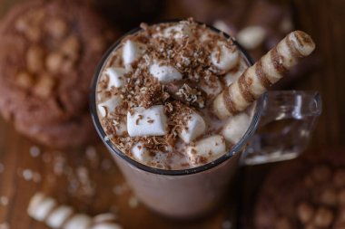 Fincan kakao marshmallows ve koyu ahşap zemin üzerine çikolatalı kurabiye. Yakın çekim.