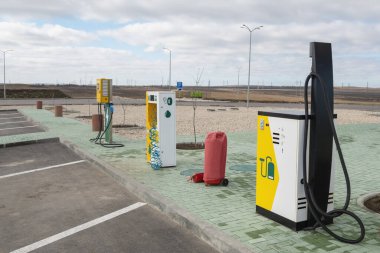 Endüstriyel elektrik süpürgesi ve benzin istasyonunda tekerlekleri şişirmek için sabit kompresör. Kırsal kesimdeki elektrikli taşıt şarj istasyonu.