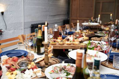 Lezzetli aperatifler ve atıştırmalıklarla dolu bir şölen masası. Restoranda süslü bardaklar ve gümüş çatal bıçaklarla servis edilen bayram ziyafeti. Düğün doğum günü partisi kutlaması.