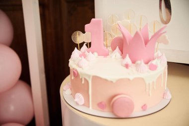 Şenlik masasında pembe ve fildişi kremalı bir pasta. Özel parti için nefis bir tatlı..