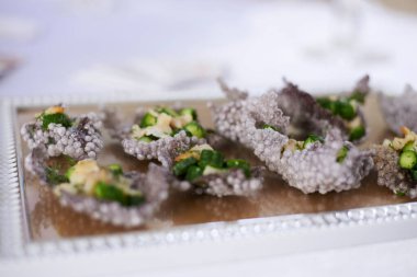 Lezzetli aperatifler ve atıştırmalıklarla dolu bir şölen masası. Restoranda süslü bardaklar ve gümüş çatal bıçaklarla servis edilen bayram ziyafeti. Düğün doğum günü partisi kutlaması.