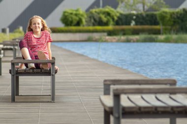 Çizgili tişörtlü neşeli bir kızın portresi..