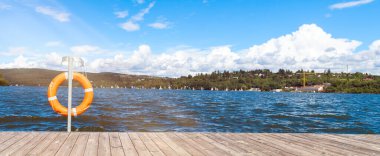 Cankurtaran şamandıralı iskele. Bedava fotokopi alanı olan bir iskele manzarası. Kurtarma konsepti. Bulutlu mavi gökyüzü.