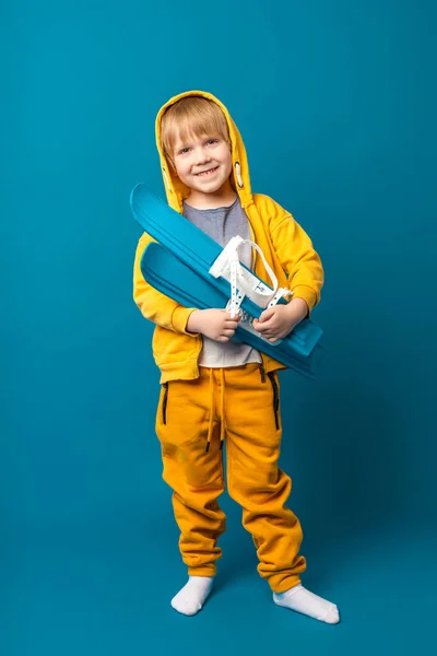 一个穿着黄色运动衫 手里拿着滑雪板的孩子 儿童休闲和体育概念 垂直射击 — 图库照片