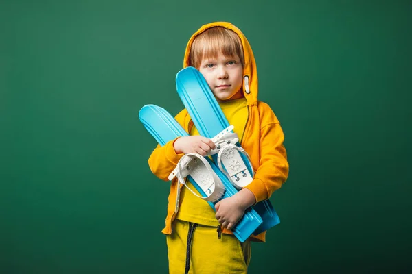 穿着黄色运动衫 手里拿着滑雪板的小男孩 儿童休闲和体育概念 — 图库照片