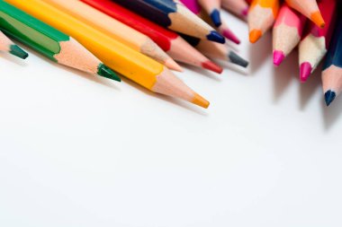 Beyaz kağıt üzerinde bir sürü çok renkli kalem var. Metnin için yer.