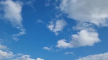 Kümülüs ve sirrus bulutlarıyla açık mavi gökyüzü. Zaman ayarlı 4K. Temiz hava ekolojisi. Hava tahminleri.