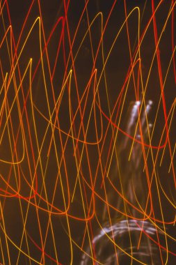 Abstract effect from glow garlands. Red lines on a black background. Vertical backdrop. Holiday wrap.