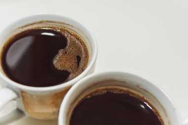 Hafif arka planda iki kahve fincanı. Seçici odaklanma. Bir açıyla üstteki görünüm.