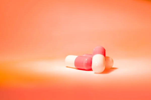 Three Red White Pill Capsules Slide Orange Background Gradient Pharmacy — Stockfoto