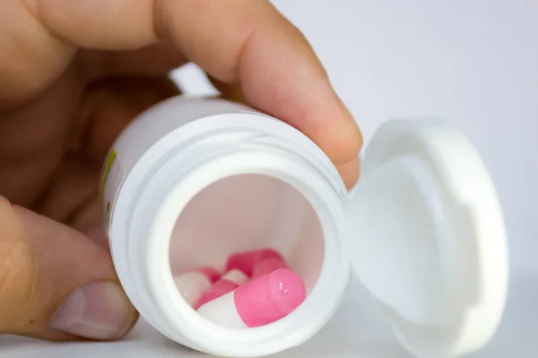 Plastic Jar White Pink Pills Capsules Person Hand Medicine Pharmaceuticals — Stockfoto