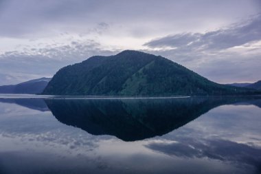 Gün batımında Yenisei nehrinin yansımasında güzel Sayan dağları
