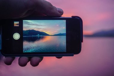 Güzel günbatımı bir cep telefonuyla çekiliyor.