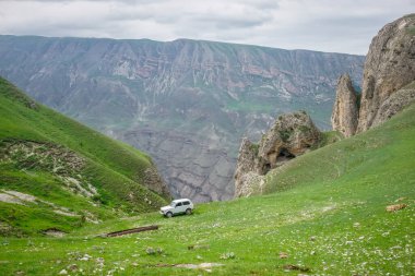Dağıstan 'daki Sulak Kanyonu' nda yeşil çimenlikte bir araba.