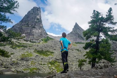 Ergaki Doğal Parkı 'ndaki Parabola Kayası' nda yürüyüşçü.